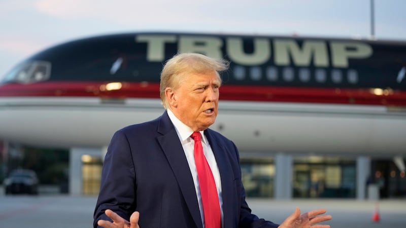 FILE - Former President Donald Trump speaks with reporters before departure from...