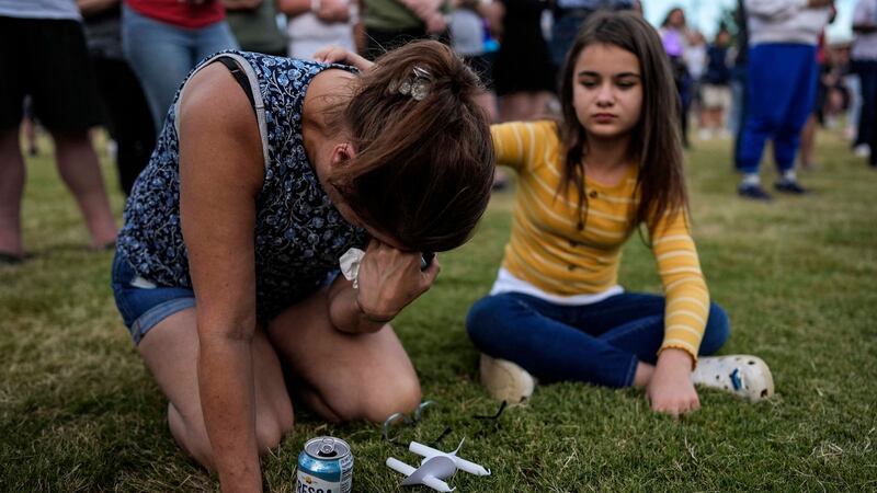 Brandy Rickaba and her daughter Emilie pray during a candlelight vigil for the slain students...