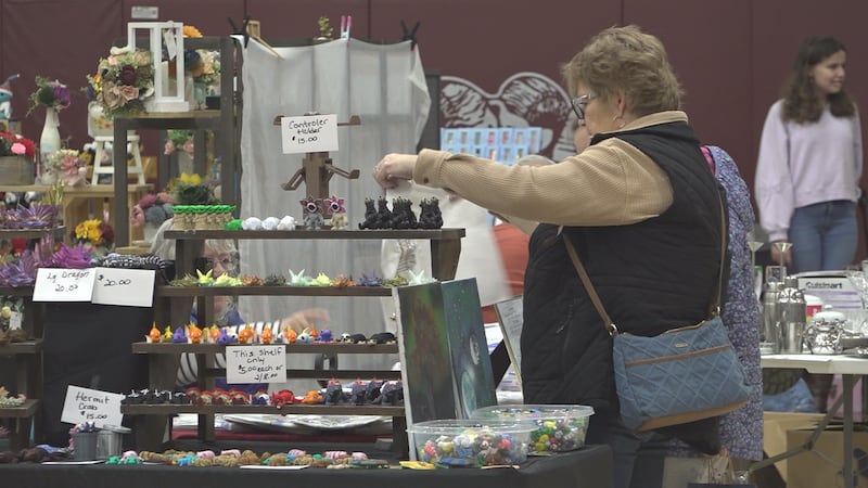 With crafters offering something for every taste, a woman is seen holding up and inspecting a...